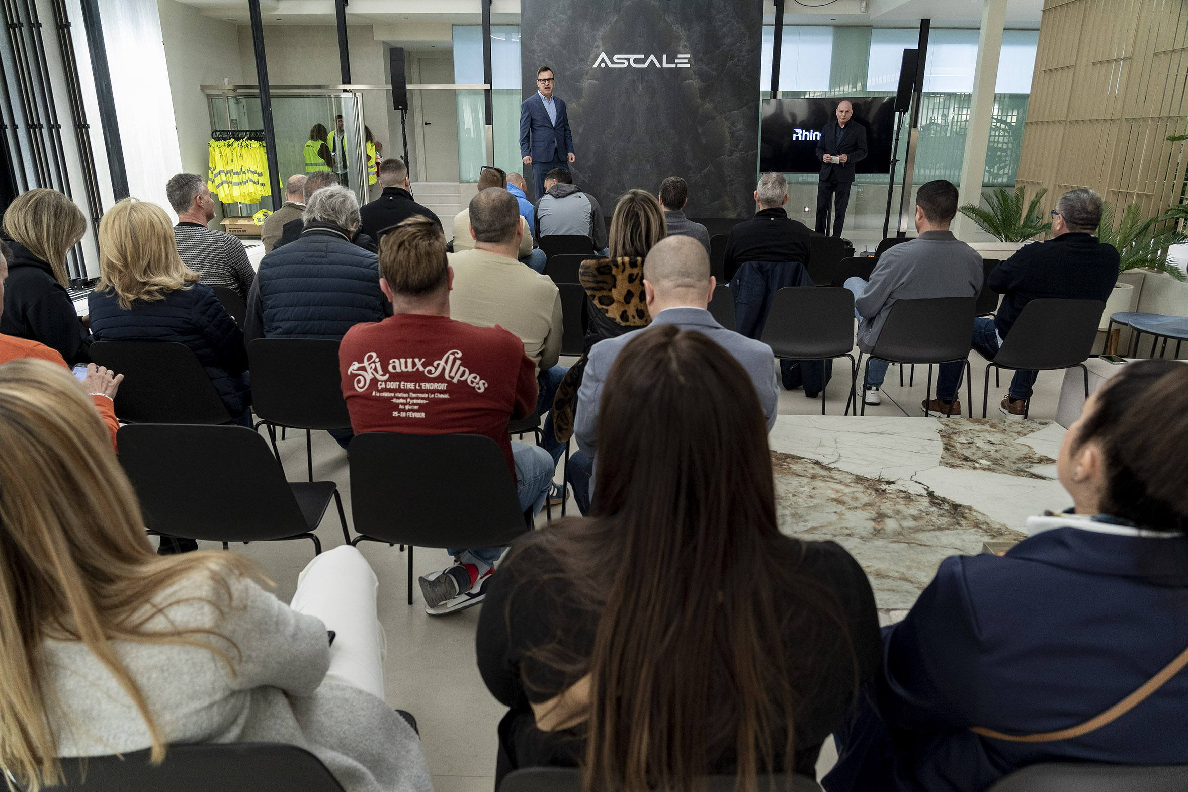 Ponente presentando la charla de Rhinostone sobre innovaciones en materiales, con un público atento a la explicación sobre la piedra sinterizada de Ascale.